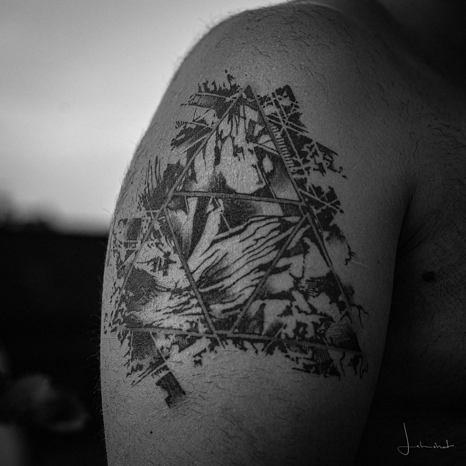Ein abstraktes Triforcetattoo auf dem Oberarm