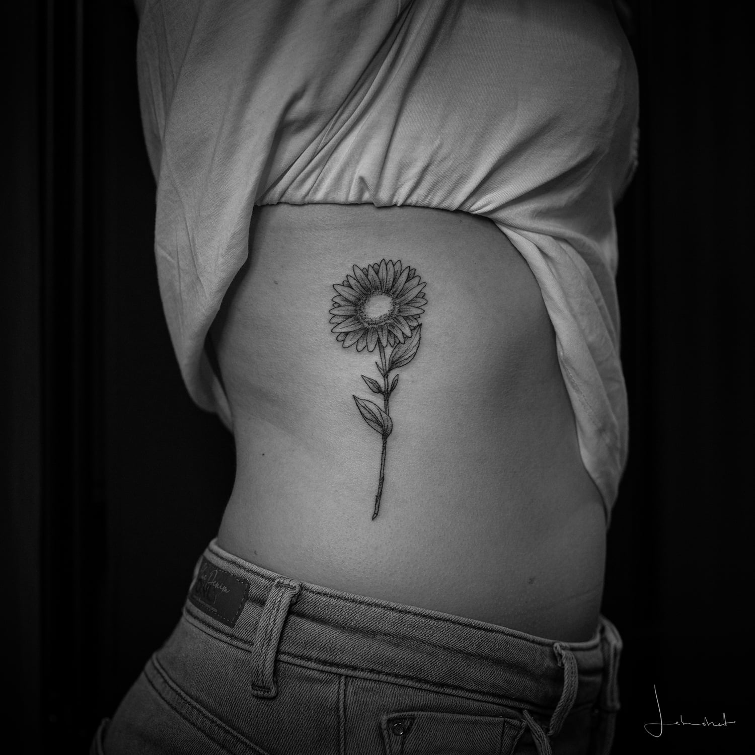 Ein Blumentattoo auf den seitlichen Rippen
